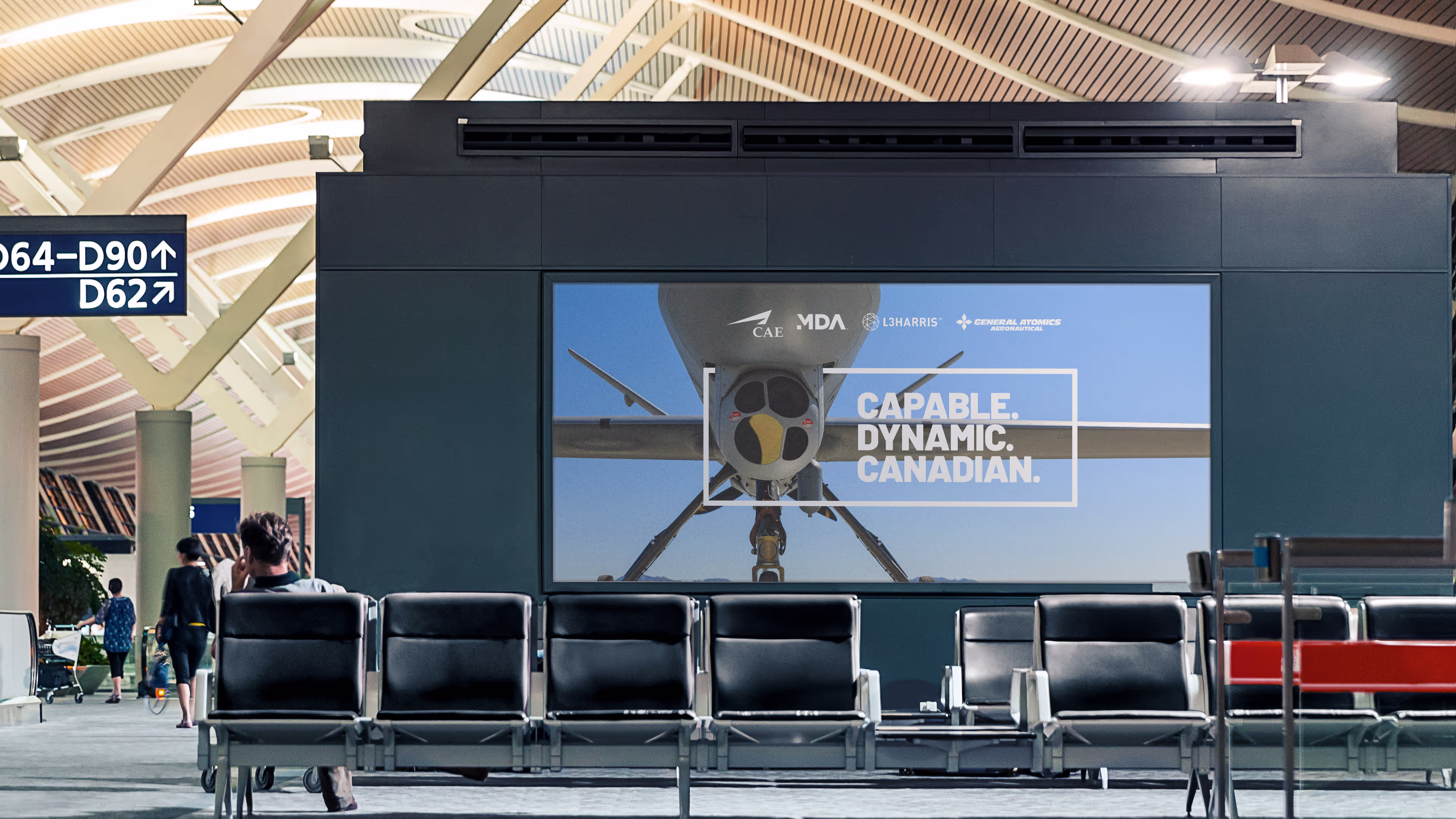 Airport lobby with a skyguardian billboard. The billboard highlights the made in Canada properties of the  MQ-9B SkyGuardian drone. The headline reads Capable, Dynamic, Canadian.