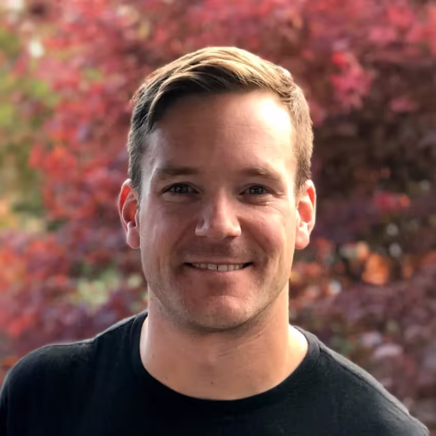 A headshot photo of Justin Prno wearing a black t-shirt